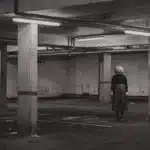 Lonely woman in a dark, empty parking garage – symbolic of fear, surveillance, and urban insecurity.