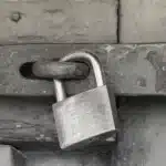 Polizeiliche Kriminalprävention Vorhängeschloss sichert eine Metalltür – Symbolbild für Kriminalprävention und technische Maßnahmen der Einbruchprävention