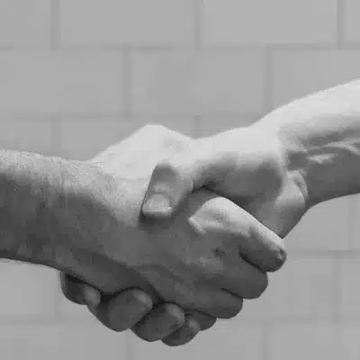 Nahaufnahme zweier Hände beim Händedruck – Symbol für soziale Ordnung und soziologische Theorien im Alltag