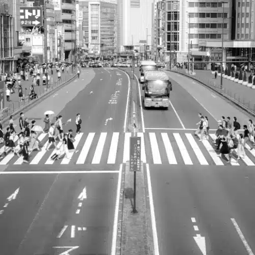 Menschen überqueren geordnet einen Zebrastreifen – Sinnbild sozialer Kontrolle und Regelbefolgung.