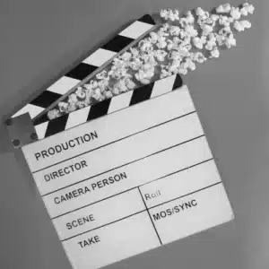 Filmklappe mit Popcorn als Symbol für die mediale Inszenierung von Kriminalität und Unterhaltung
