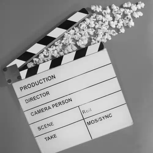 Filmklappe mit Popcorn als Symbol für die mediale Inszenierung von Kriminalität und Unterhaltung
