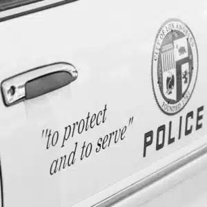 Schriftzug „To Protect and to Serve“ auf einem Polizeifahrzeug in Los Angeles – Symbolbild für Polizeiarbeit, Autorität und die Ambivalenz polizeilicher Macht in Training Day.