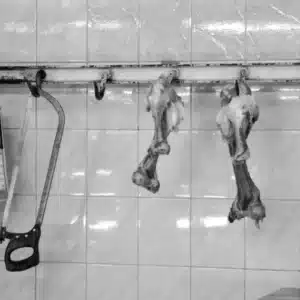 Fleischerhaken, Säge und aufgehängte Tierkörper in einem Schlachtraum – Symbolbild für den Film The Texas Chain Saw Massacre (1974)