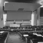 Wie funktioniert ein Studium? Hochschulsystem, Abschlüsse und Studienalltag erklärt Leerer Hörsaal einer Universität mit Reihen aus Sitzplätzen und einem Dozentenpult