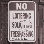 Jeff Ferrell – Tearing Down the Streets: Adventures in Urban Anarchy (2001) überklebtes und bemaltes Schild mit dem Hinweis "No-Loitering"