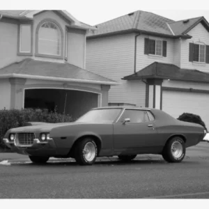 Ford Gran Torino aus den 1970er-Jahren vor amerikanischen Wohnhäusern
